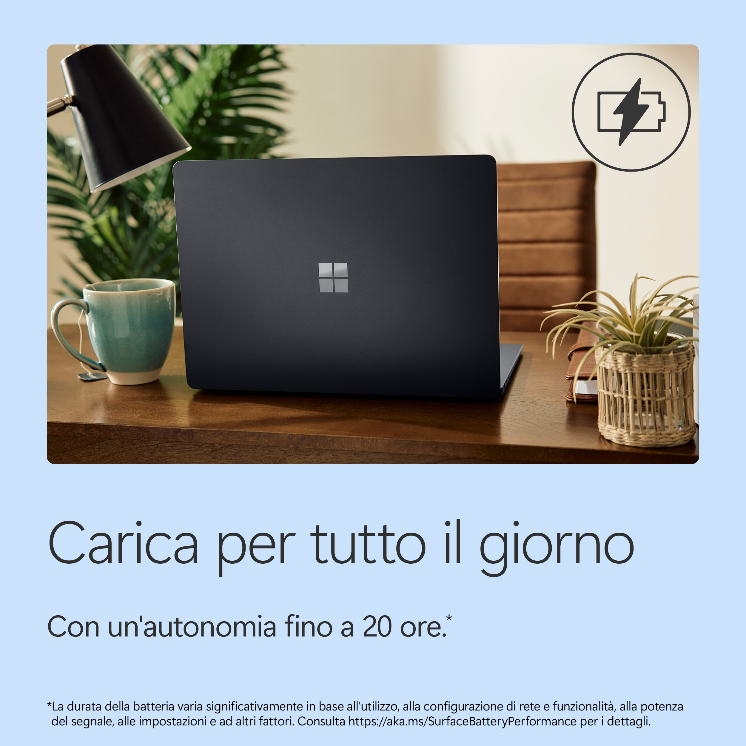 Un laptop scuro su una scrivania con tazza e pianta. Icona batteria.