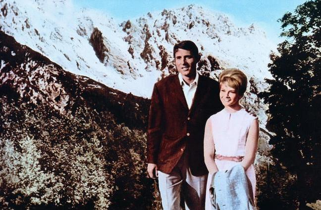Ein Mann und eine Frau stehen vor schneebedeckten Bergen.