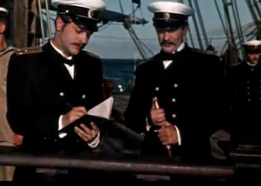 Zwei Männer in Uniformen auf einem Schiff, einer schreibt, der andere hält etwas.