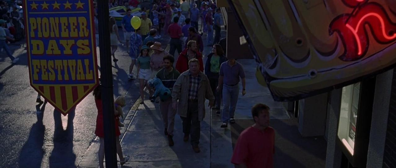 Menschen gehen eine Straße entlang an einem Banner für das Pioneer Days Festival vorbei.