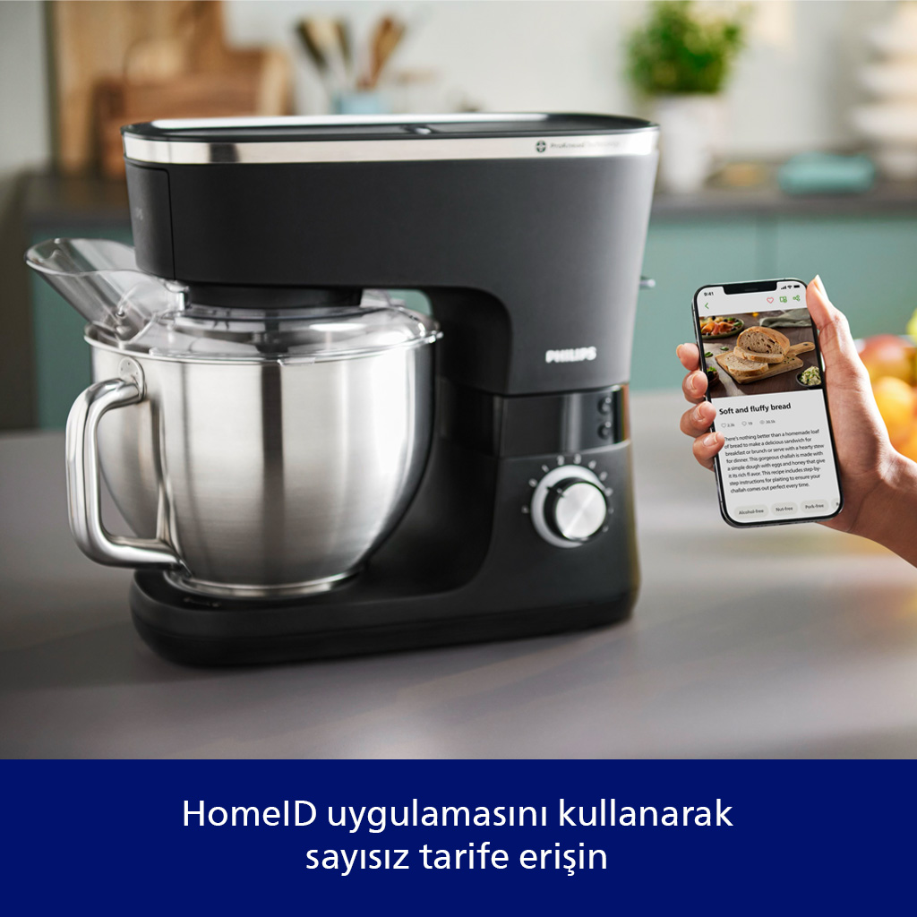 Paslanmaz çelik hazneye sahip siyah stand mikseri ve ekmek tarifi gösteren akıllı telefon.