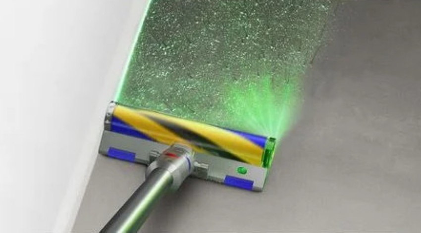 Głowica odkurzacza z zielonym światłem laserowym oświetla podłogę.