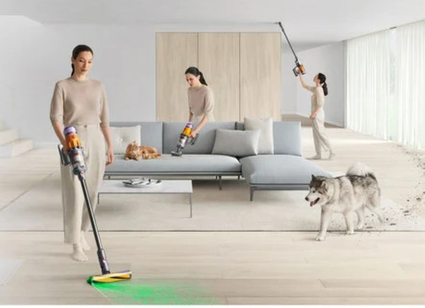 Trzy kobiety sprzątają jasny salon odkurzaczami Dyson. Obecne są pies i kot.