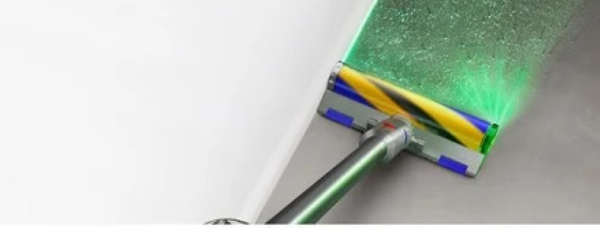 Szczotka odkurzacza z zielonym światłem laserowym czyści podłogę.