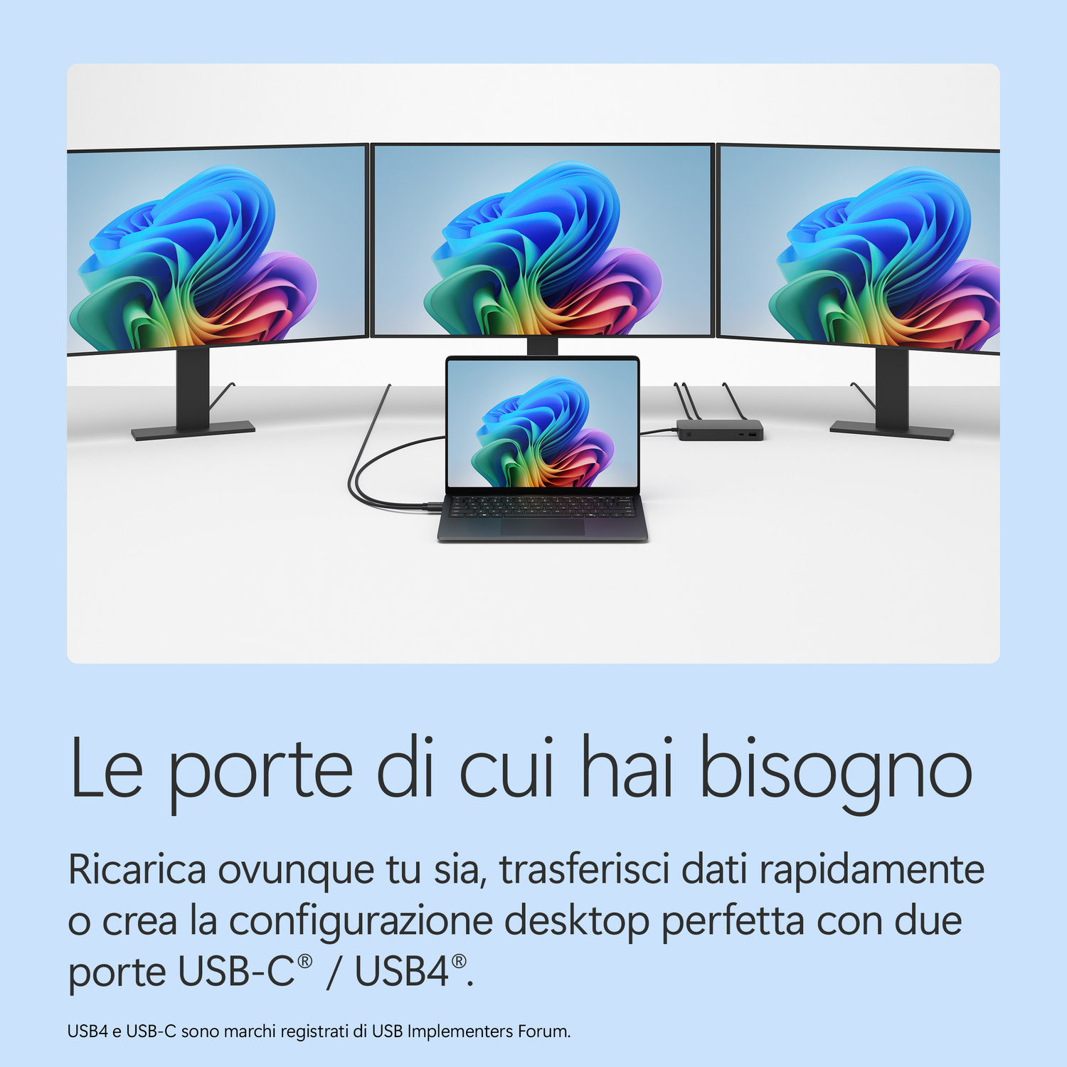Tre monitor e un laptop collegati su una scrivania con un hub di docking.