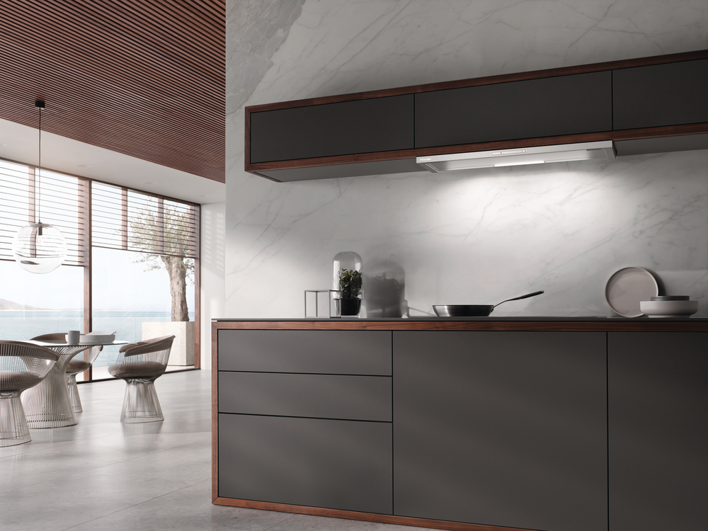 Koyu dolaplı, mermer backsplashli ve yemek alanlı modern mutfak.