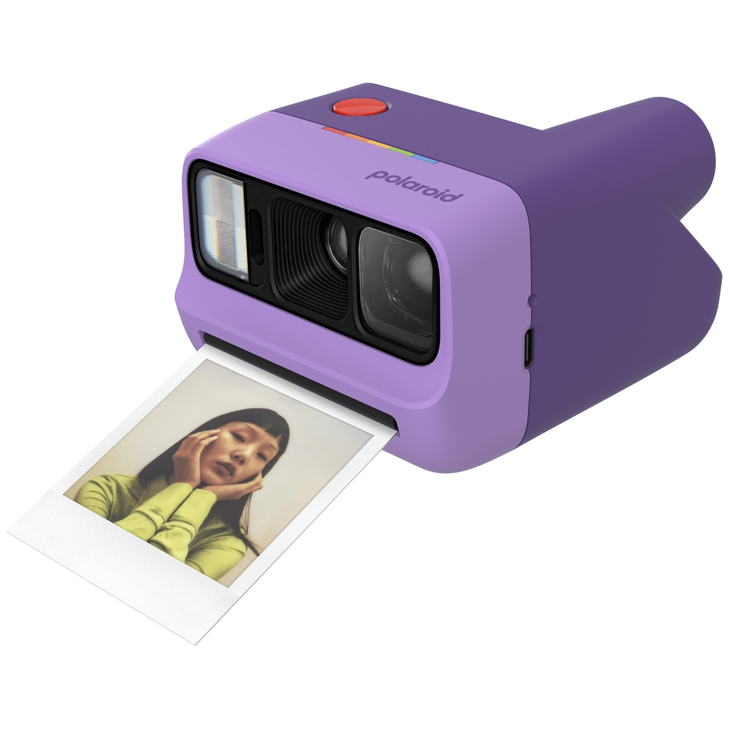 Appareil photo Polaroid violet avec bouton rouge et une photo imprimée.