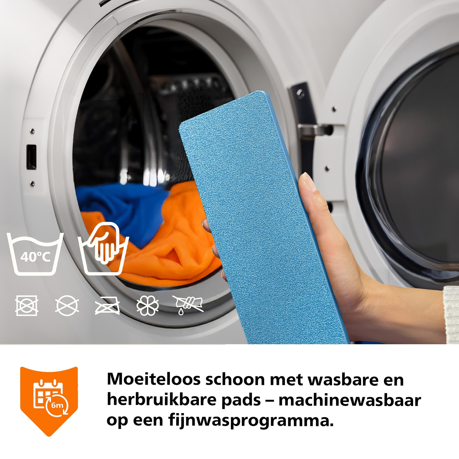 Une main tient une éponge bleue devant une machine à laver avec du linge.