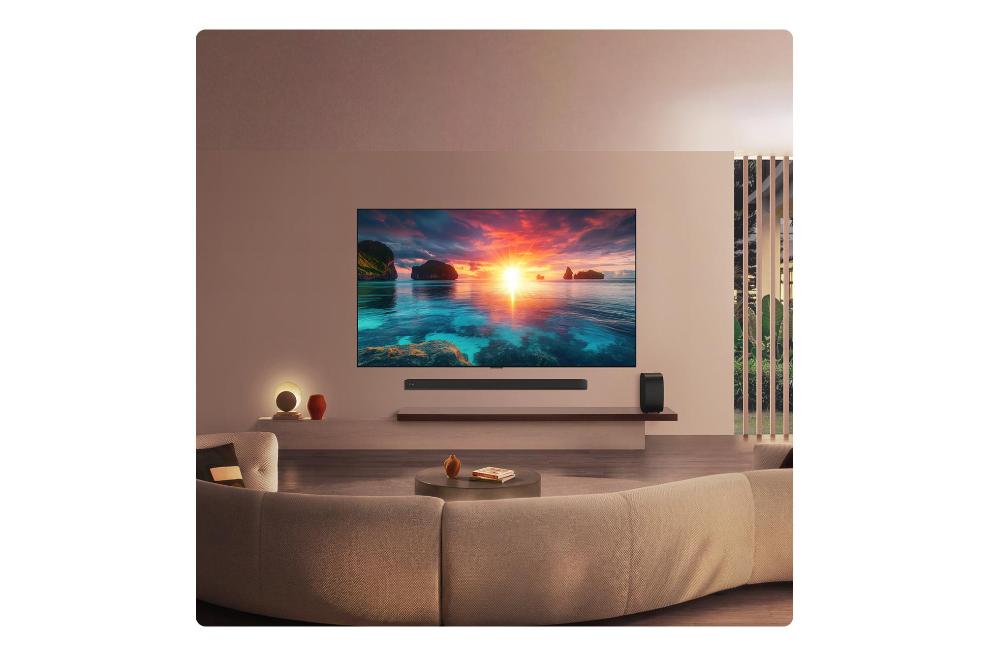 Ein Wohnzimmer mit Sofa, Fernseher, der einen Sonnenuntergang zeigt, und Pflanzen.