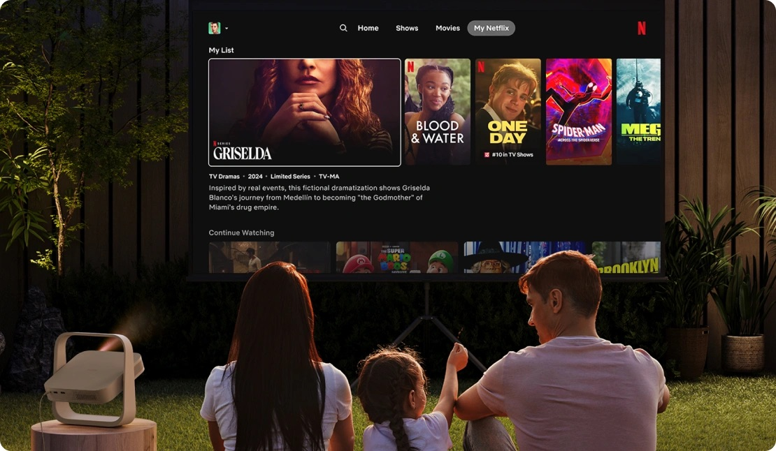 Aile açık havada Netflix izliyor. Projektör filmleri ekrana yansıtıyor.