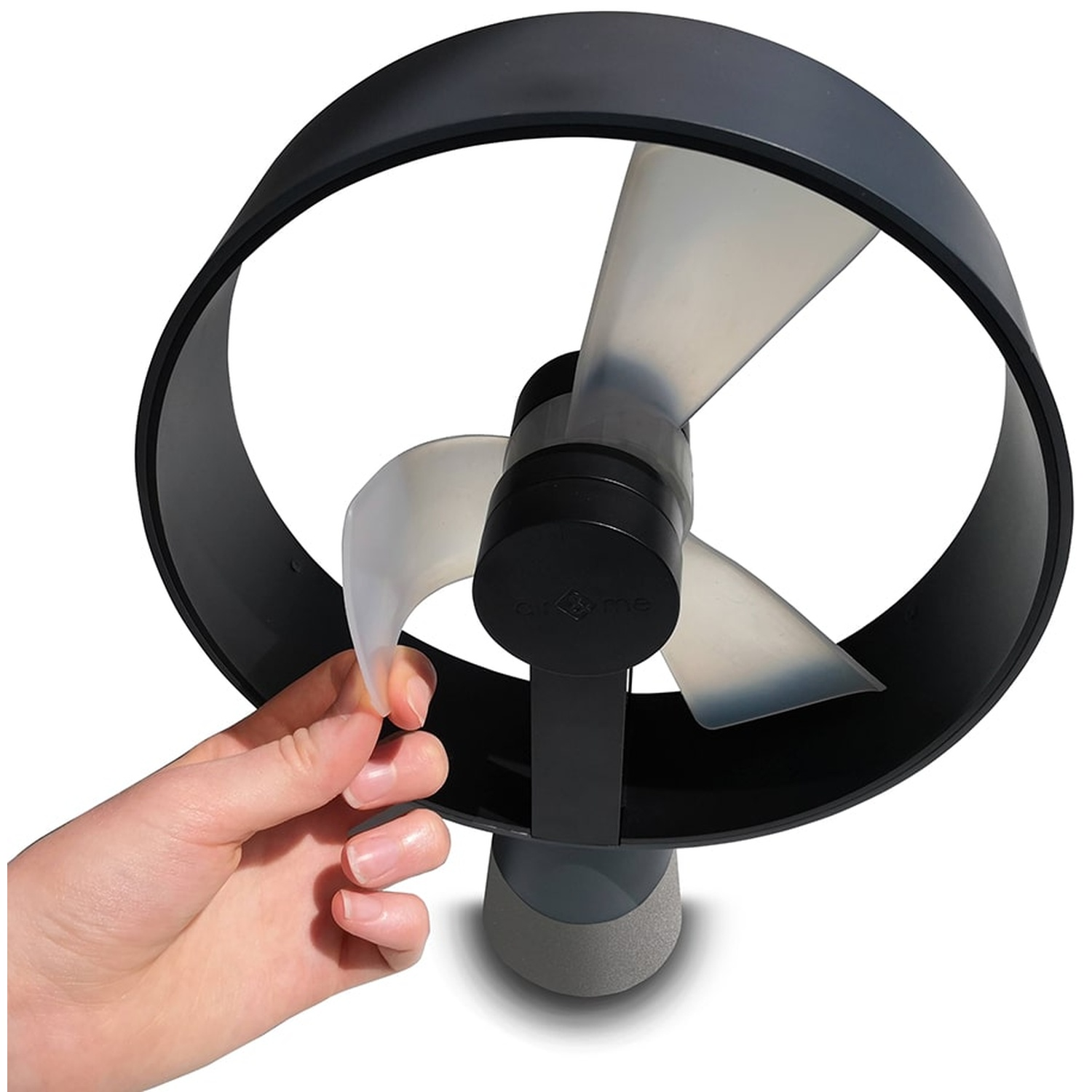 Een hand raakt het doorschijnende blad van een grijze ventilator aan.