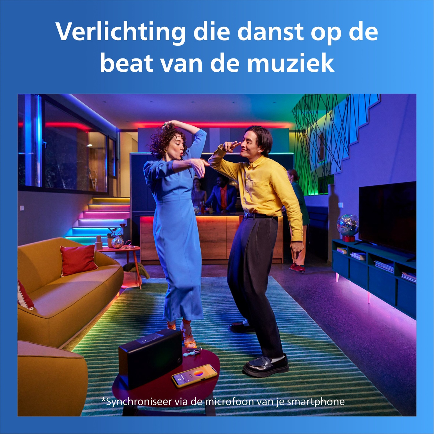 Twee mensen dansen op muziek in een modern, kleurrijk verlichte kamer.