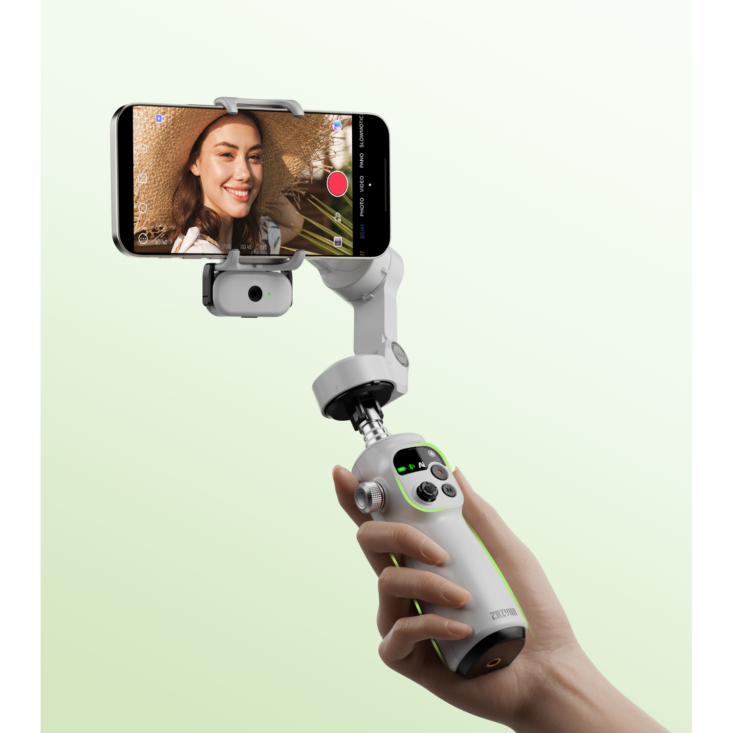 Een hand houdt een gimbal vast met een smartphone die een lachend gezicht toont.