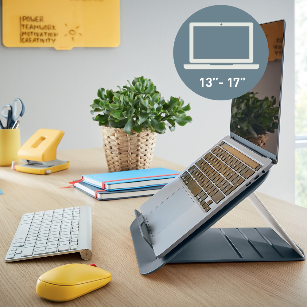 Laptopállvány laptop, billentyűzet, egér, jegyzetfüzetek és növény.