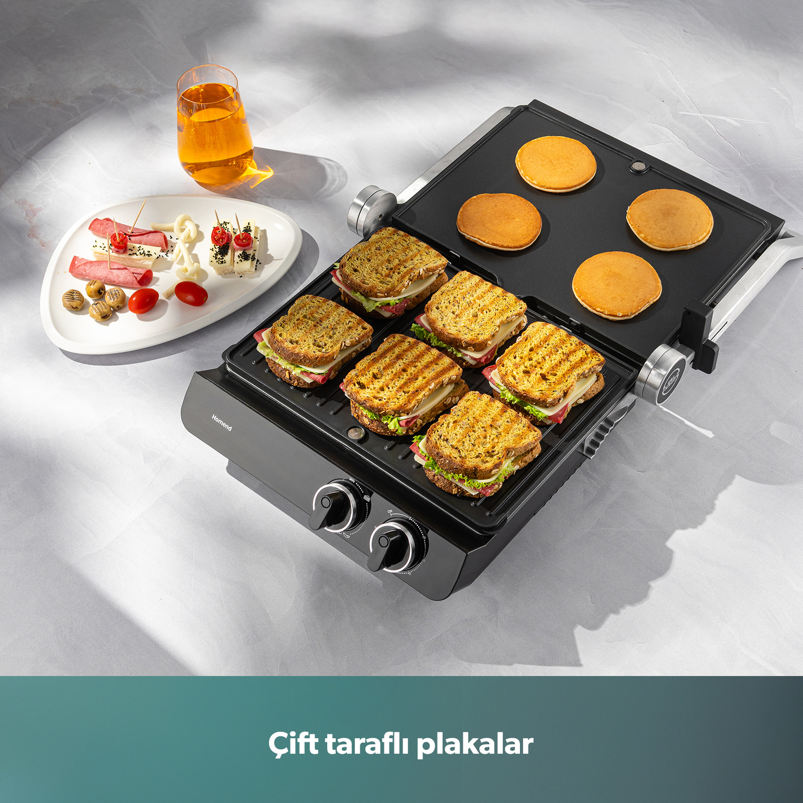 Sandviç ve pankekler olan bir sandviç makinesi. Yanında bir bardak meyve suyu ve meze tabağı.