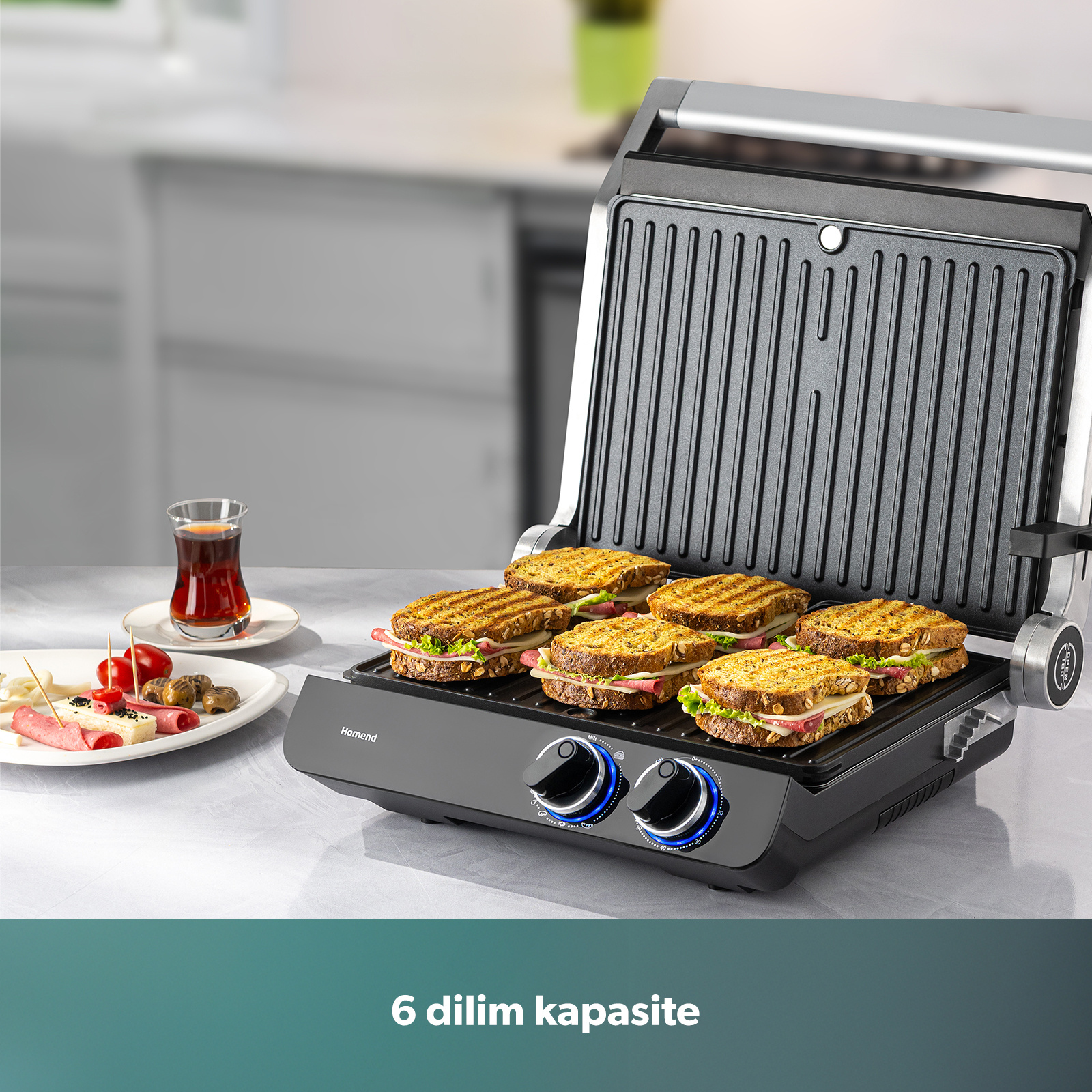 Altı adet hazır sandviç ve yanında bir bardak çay bulunan bir sandviç makinesi.