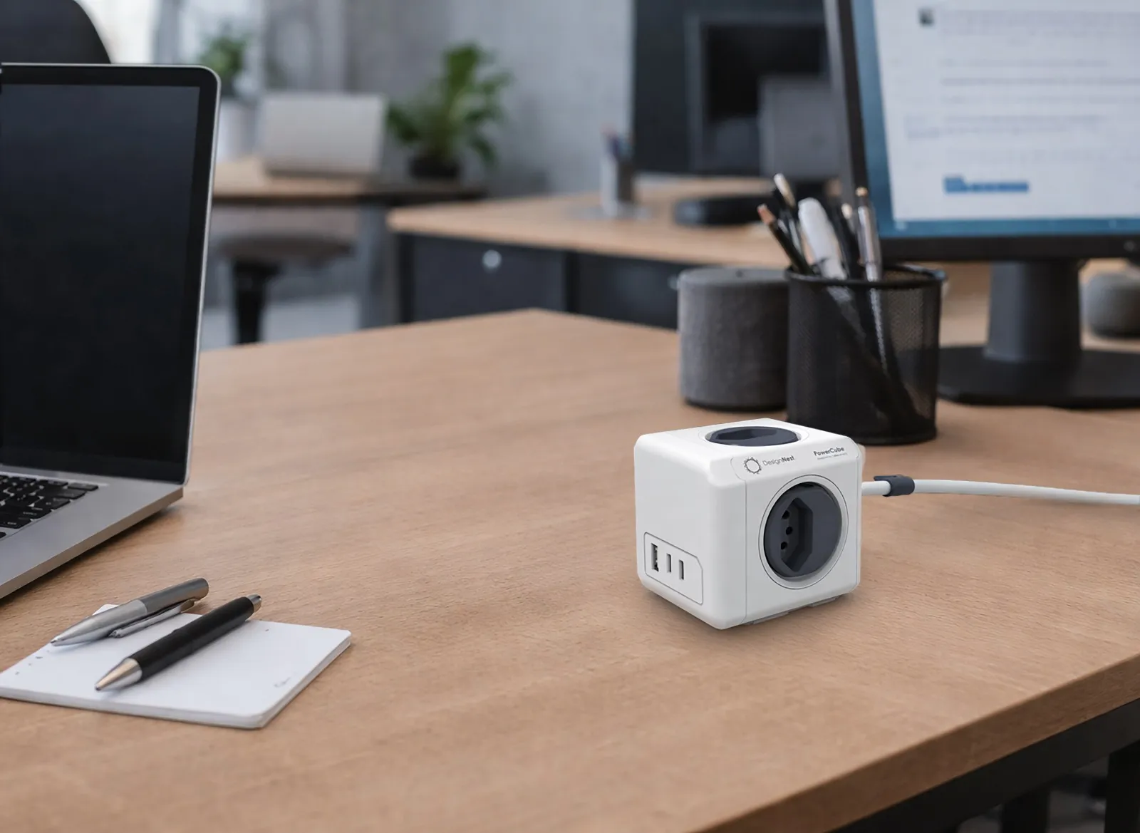 Ein weißer PowerCube mit Steckdosen und USB-Anschlüssen auf einem Schreibtisch.