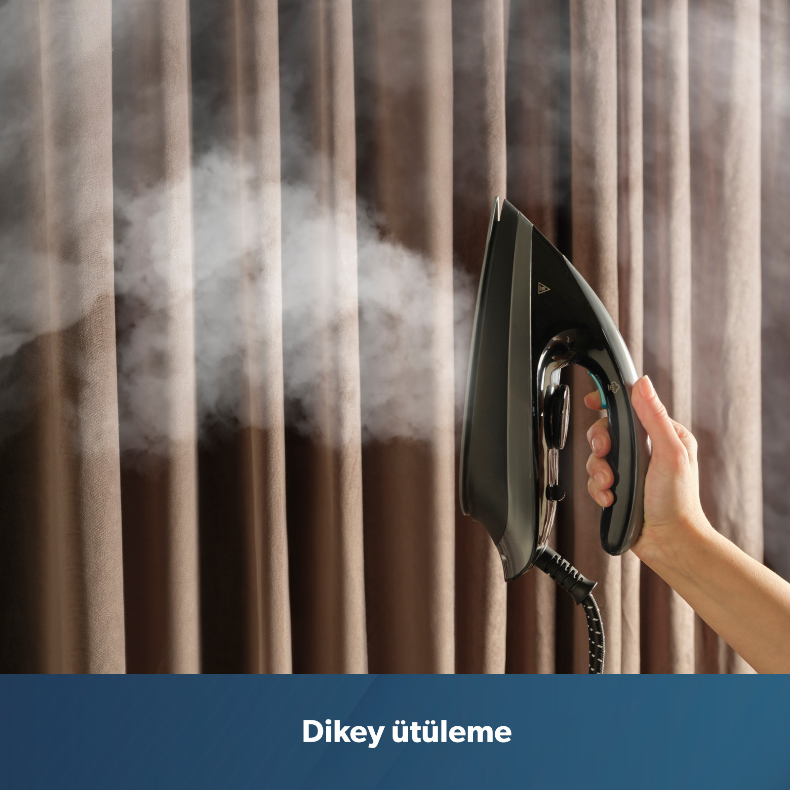 Bir el, buhar çıkaran kahverengi perdelerin önünde siyah bir buharlı ütü tutuyor.