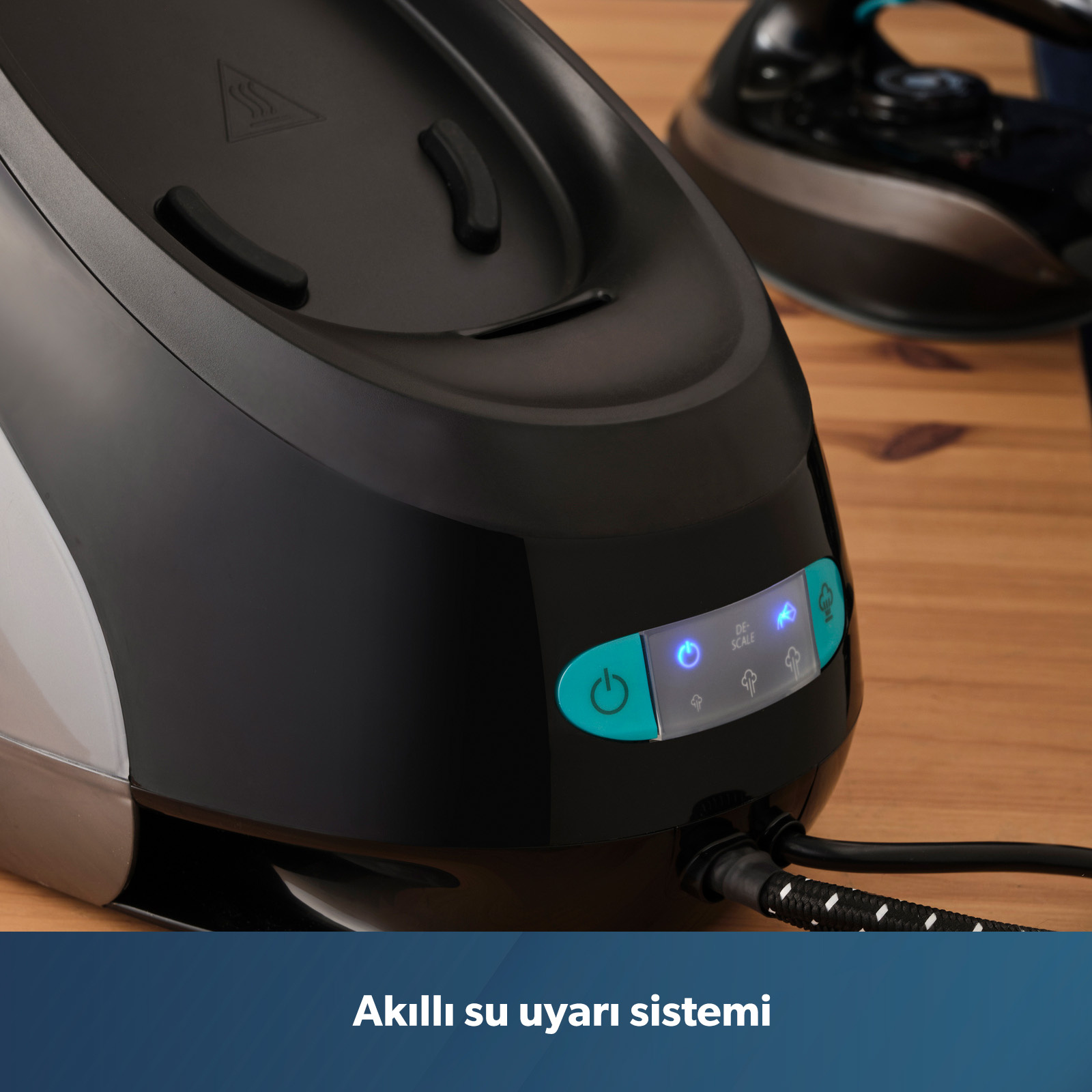 Arkada ütü bulunan mavi ışıklı siyah buharlı ütü tabanı.