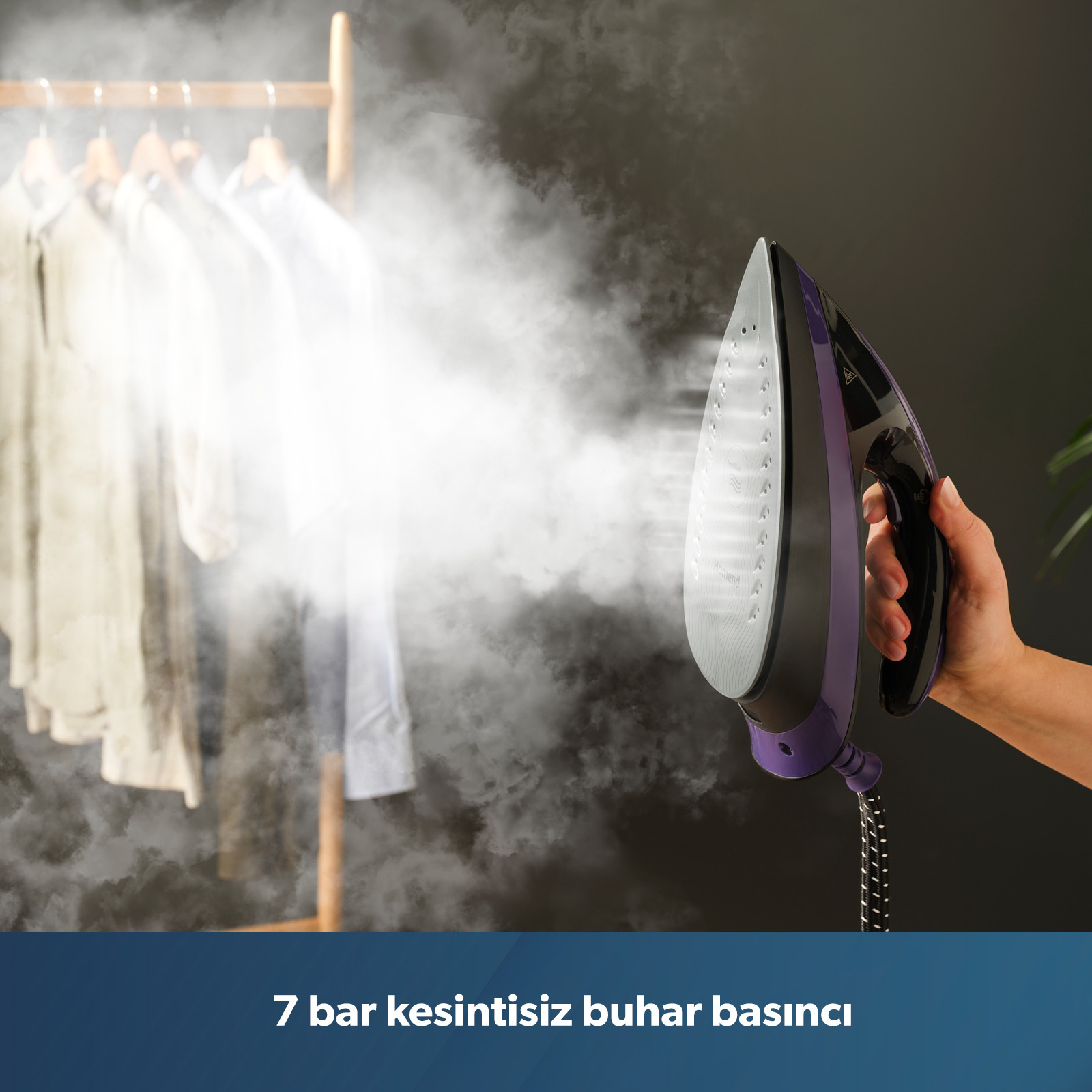 Bir el, kıyafetlere buhar püskürten mor bir buharlı ütü tutuyor.
