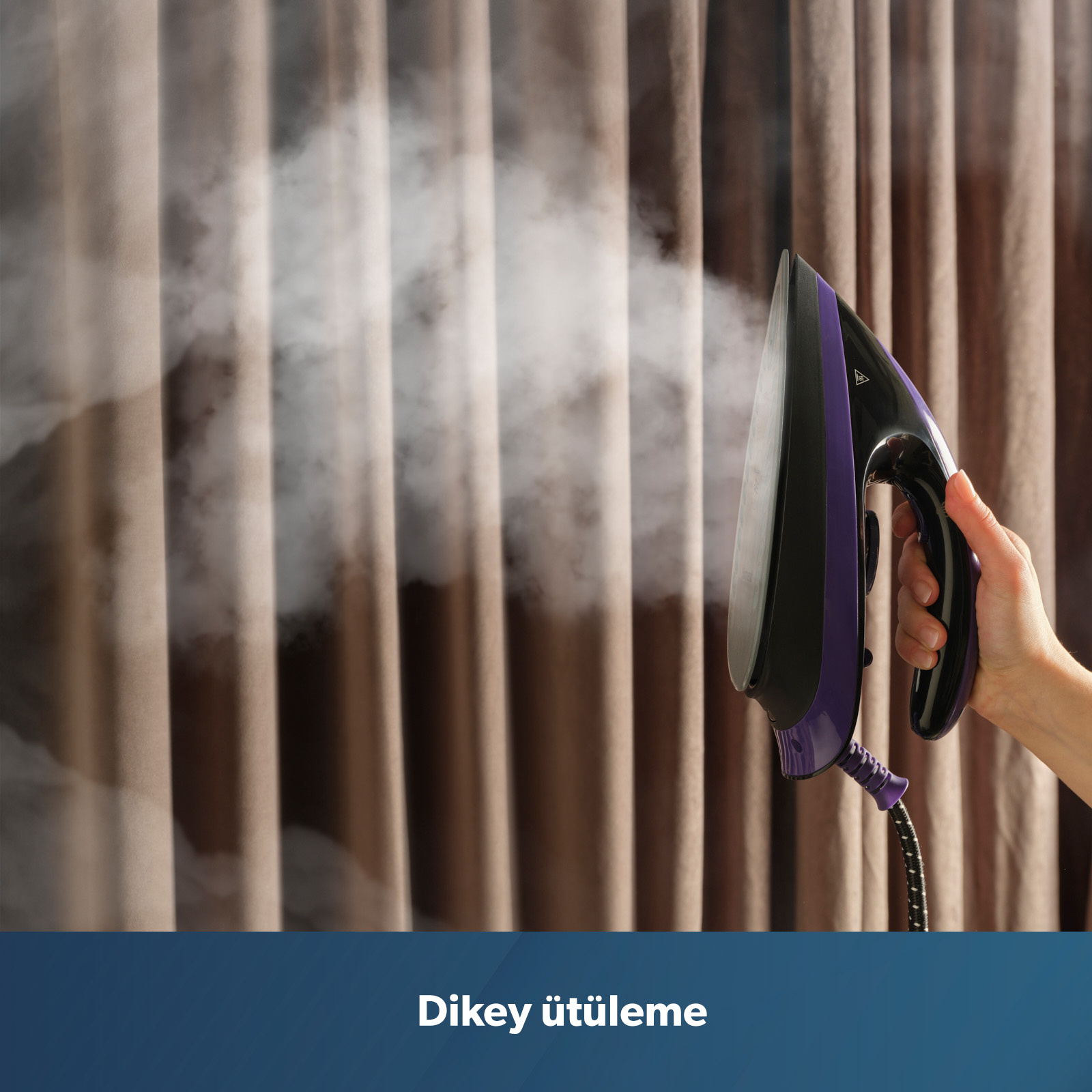 Bir el, kahverengi perdelerin önünde mor ve siyah buharlı ütü tutuyor.