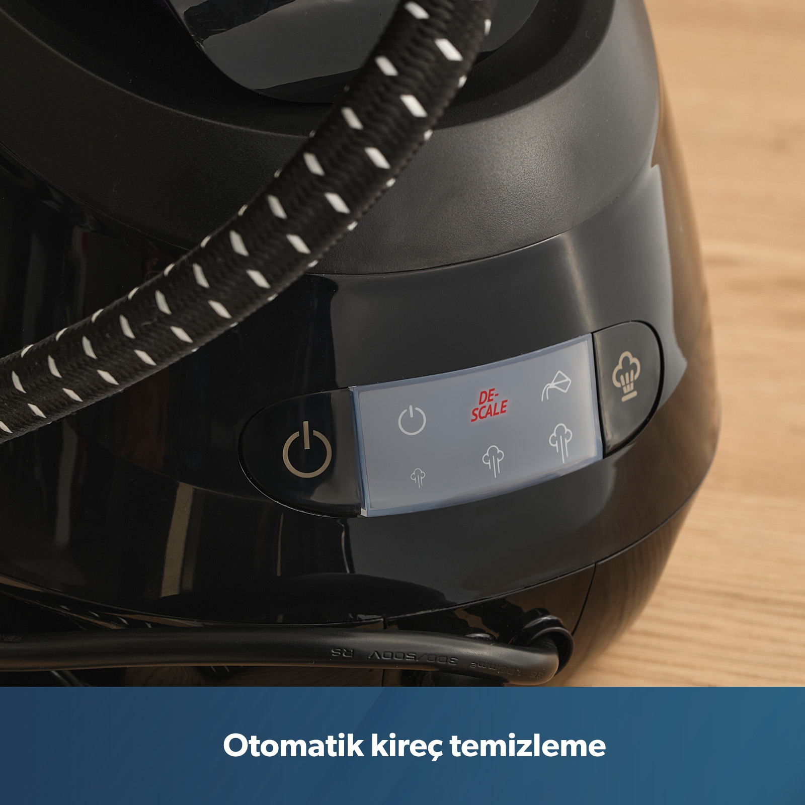Kontrol düğmeleri ve 'DE-SCALE' göstergesi olan siyah buharlı ütünün yakın çekimi.