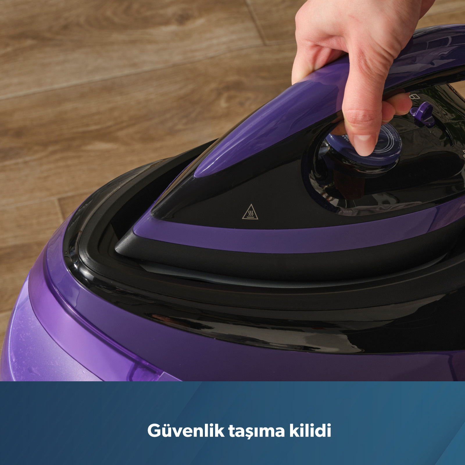 Ahşap zeminde kadranlı mor ve siyah ütüyü el ile çalıştırma.