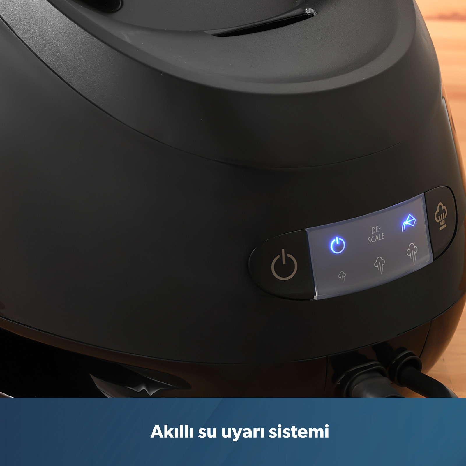 Siyah buharli ütü, aydinlatilmiş güç ve kireç giderme simgeleriyle.