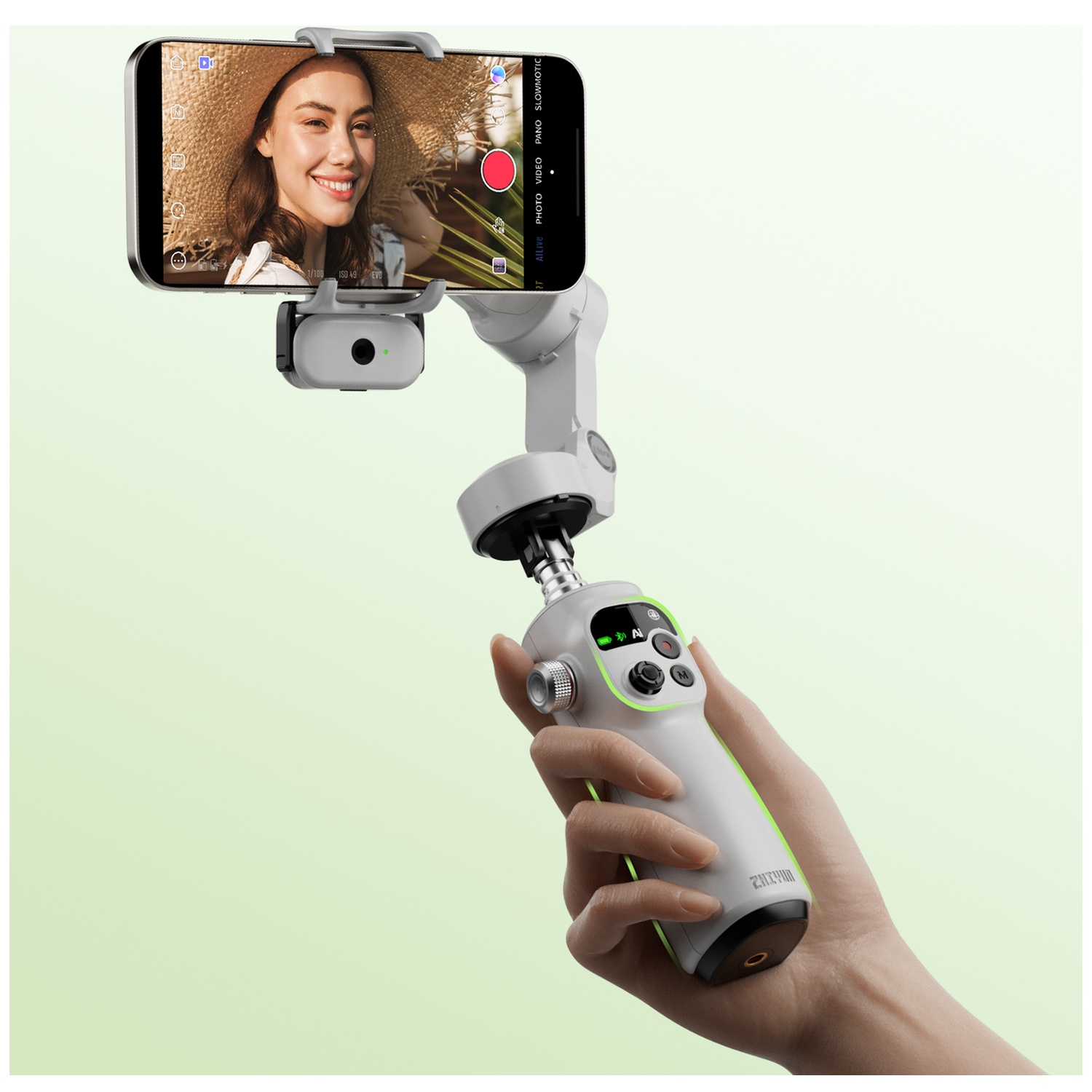 Une main tient un stabilisateur avec un smartphone affichant la photo d'une femme.