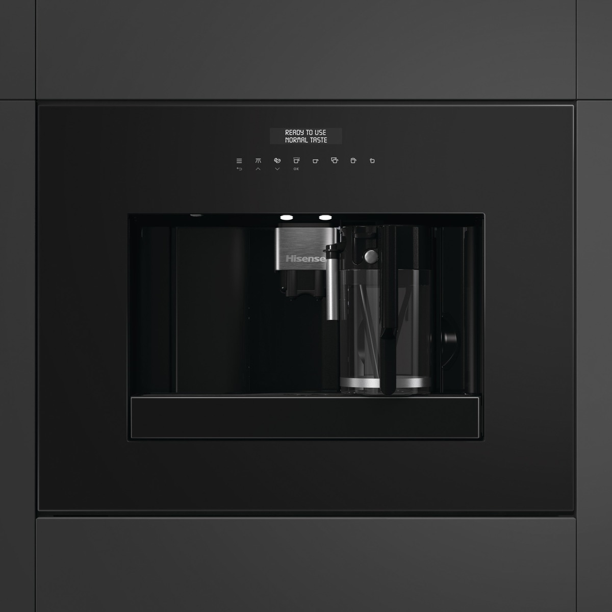 Ein schwarzer Kaffeevollautomat mit einem Glas, bereit zur Benutzung. Display zeigt 'READY TO USE'.