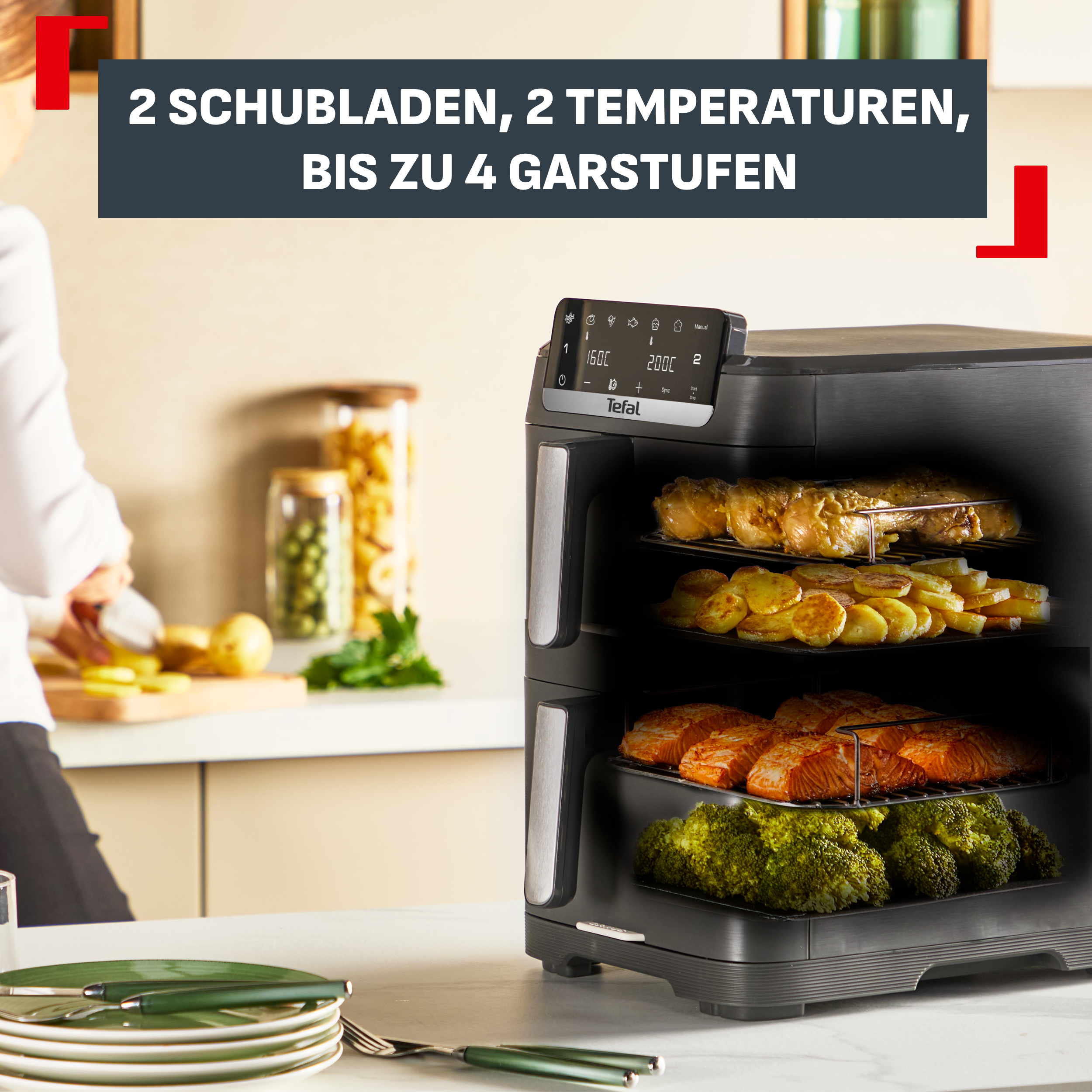 Ein Tefal Heißluftfritteuse mit zwei Schubladen, gefüllt mit Hähnchen, Kartoffeln, Lachs und Brokkoli.