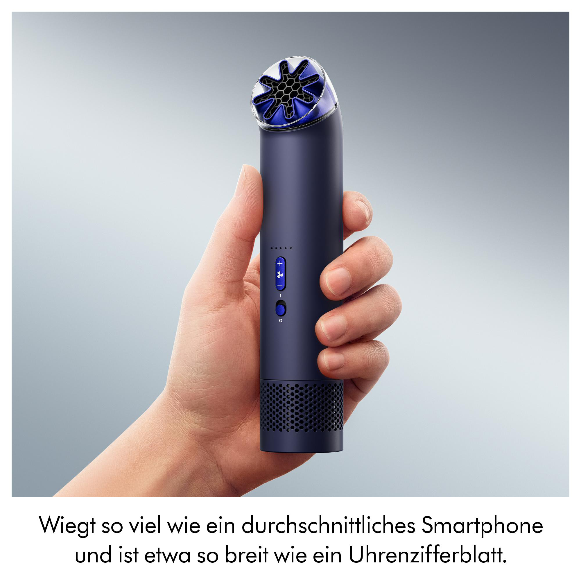 Eine Hand hält ein dunkles, zylindrisches Gerät mit blauem Lüftergitter oben.