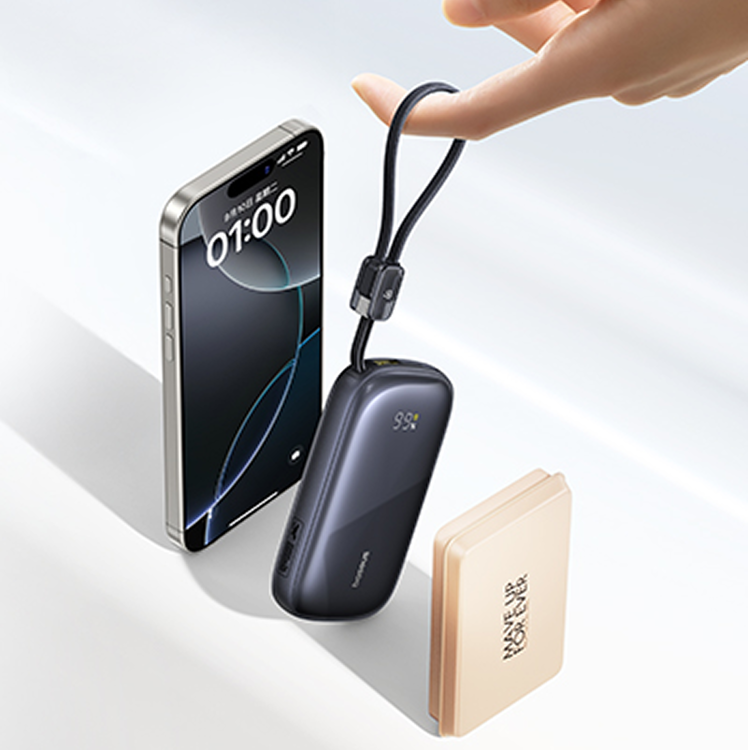 Una mano sostiene un cargador portátil negro cerca de un teléfono y un compacto de maquillaje.