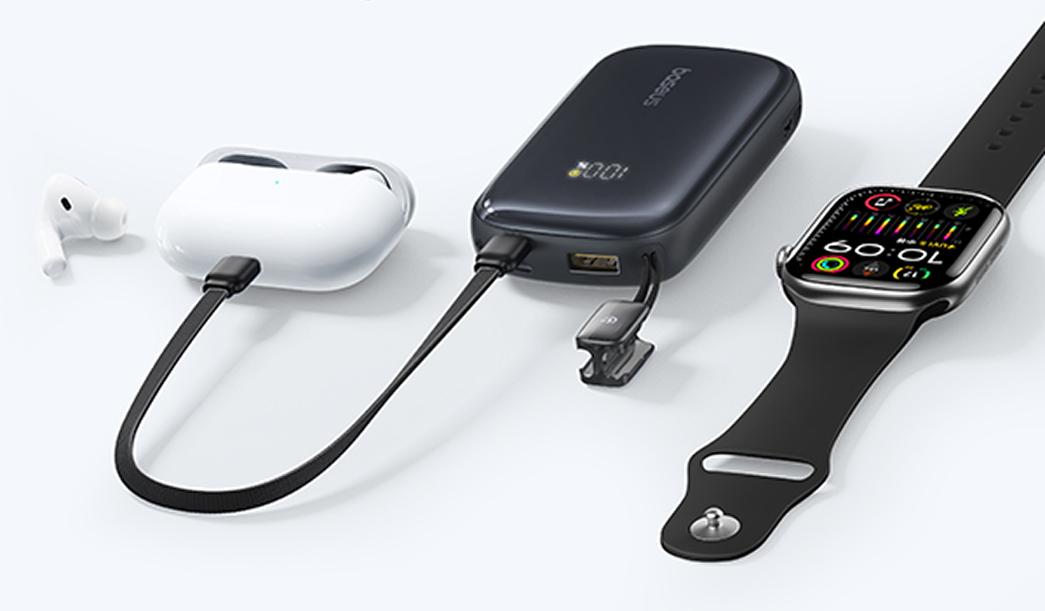 Batería externa negra cargando auriculares blancos y reloj inteligente sobre fondo blanco.