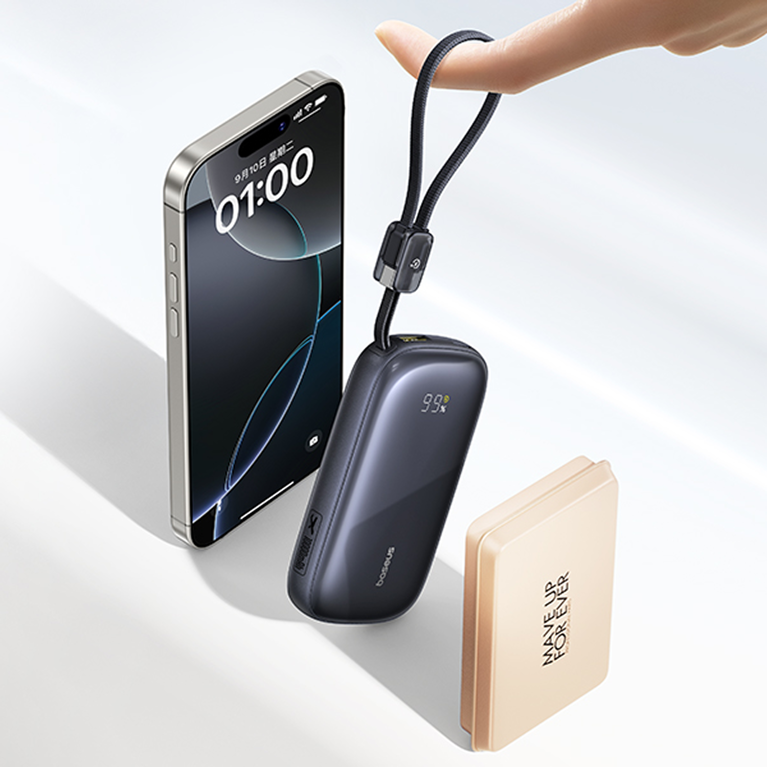 Una persona sostiene un power bank con cordón junto a un smartphone y un estuche de maquillaje.