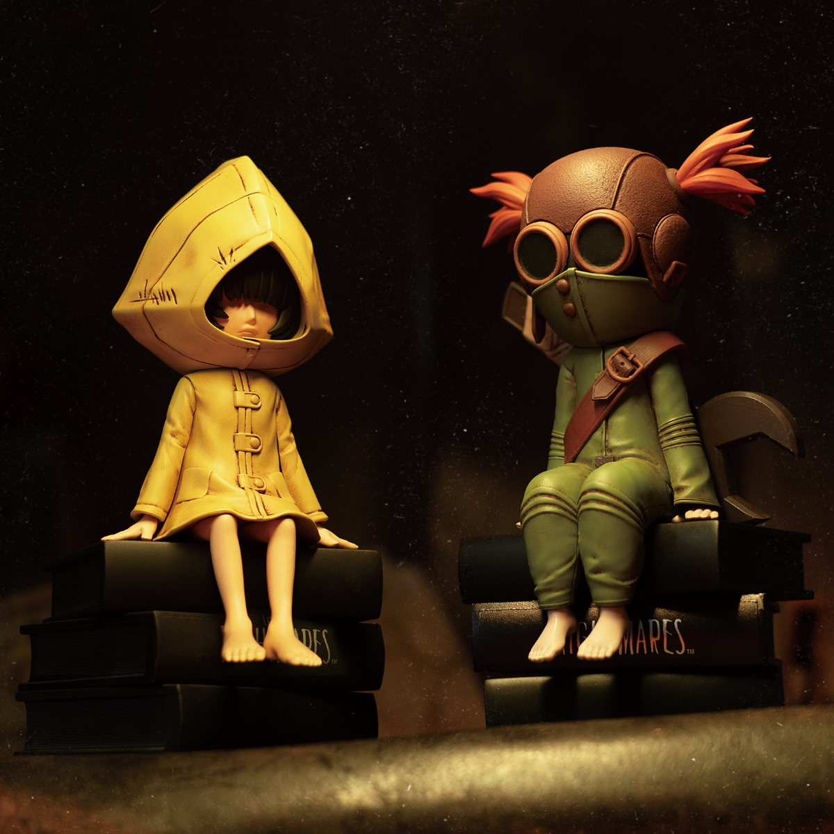 Dos figuras sentadas sobre libros. Una lleva un impermeable amarillo, la otra un uniforme verde.