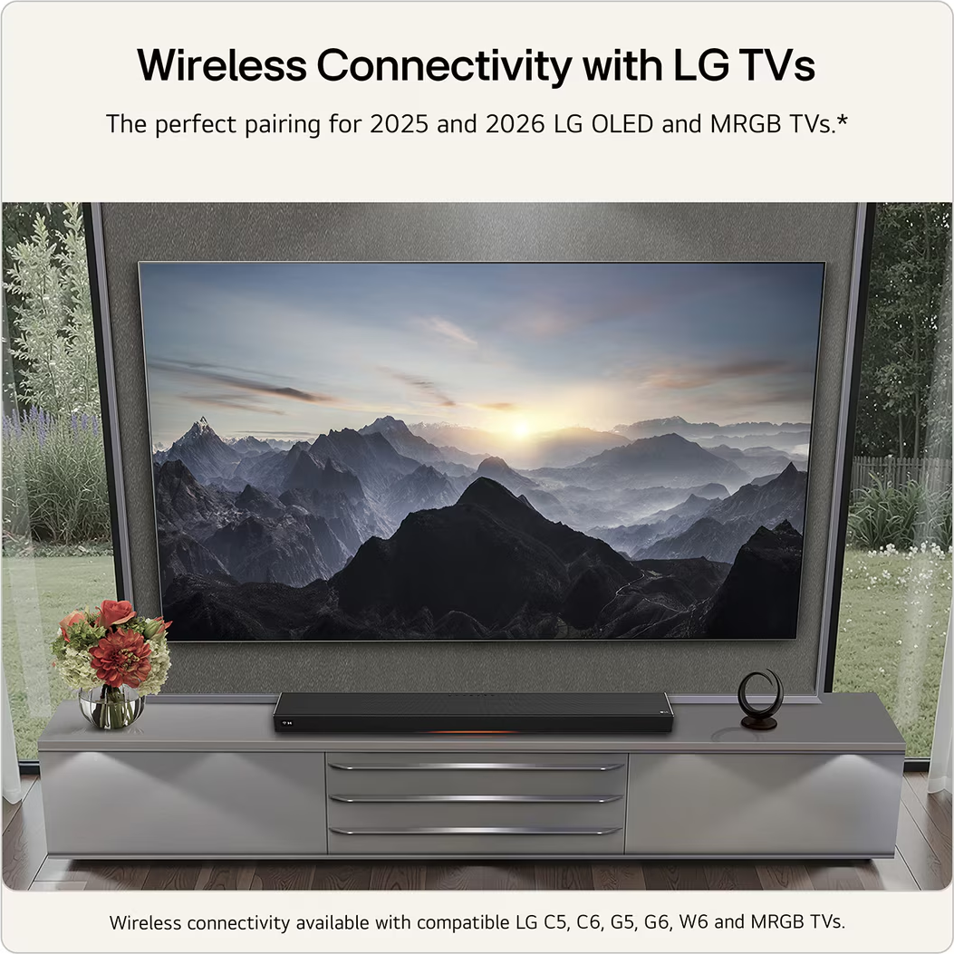 Une TV LG avec une barre de son et un bouquet de fleurs sur un buffet.