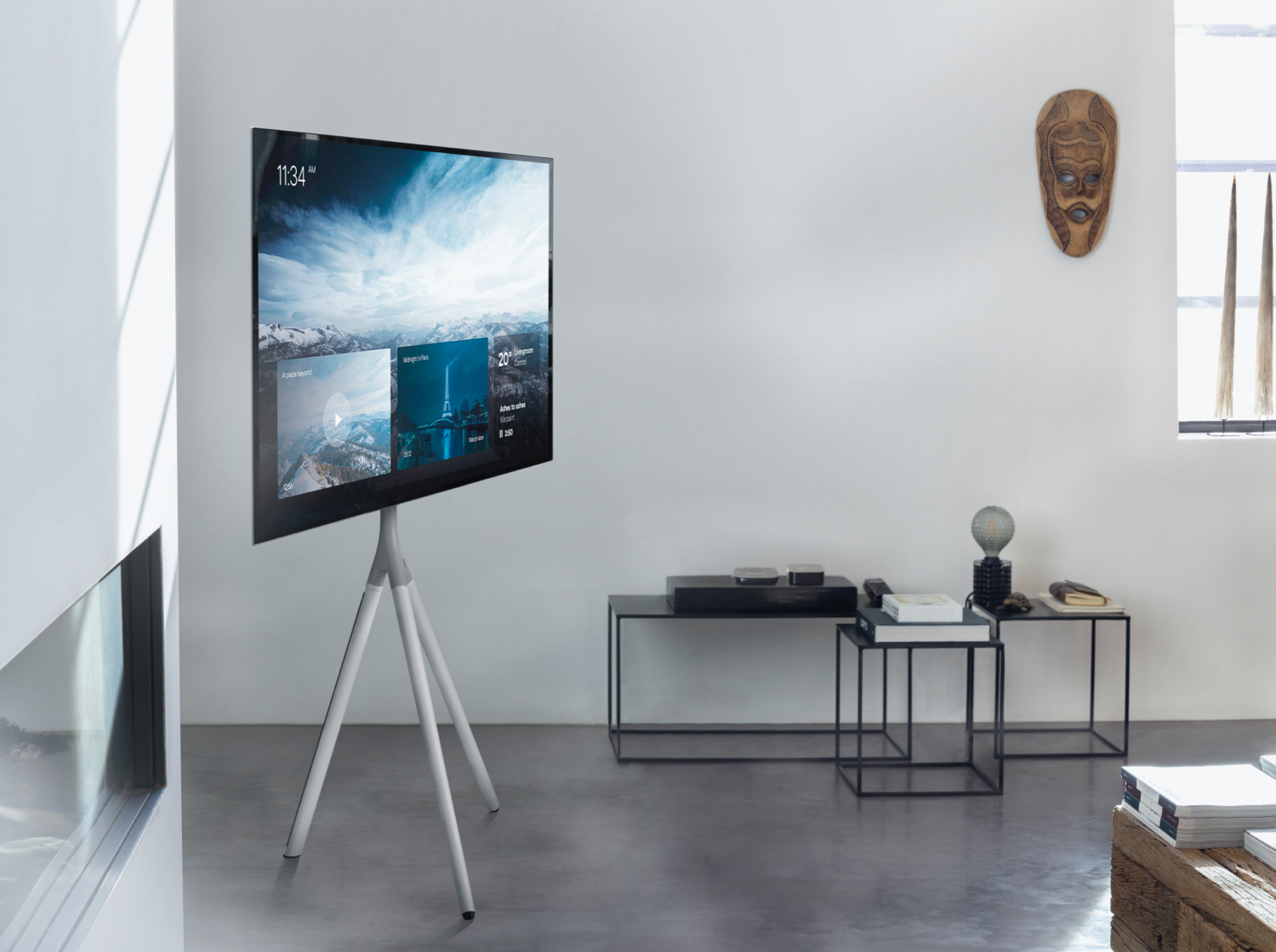 Un televisor moderno sobre un trípode en una sala minimalista.