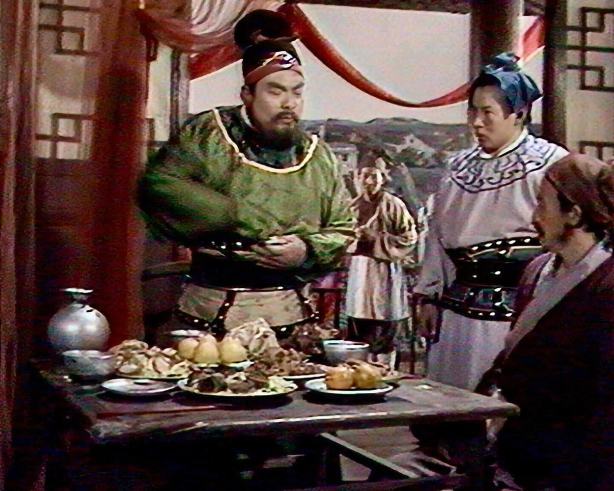 Eine Gruppe von Menschen in traditioneller Kleidung steht um einen Tisch mit Essen.