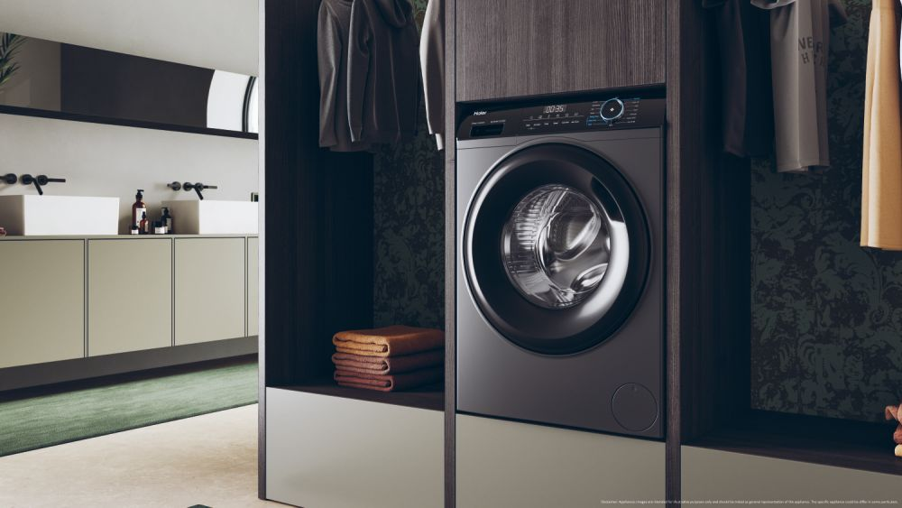 Çamaşır makinesi, iki lavabo ve giysilerin bulunduğu modern çamaşır odası.
