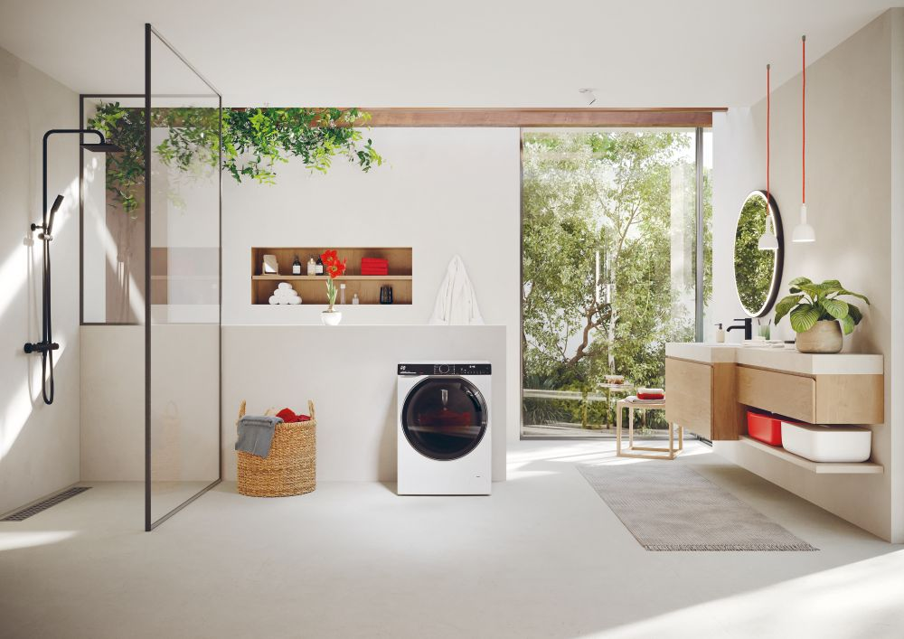 Modern bir banyo; çamaşır makinesi, duş, lavabo ve bol yeşillik.