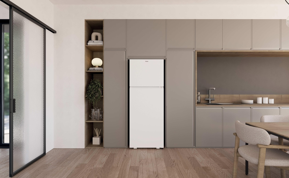 Modern bir mutfakta gri dolaplar ve ahşap vurgularla beyaz bir Haier buzdolabı duruyor.