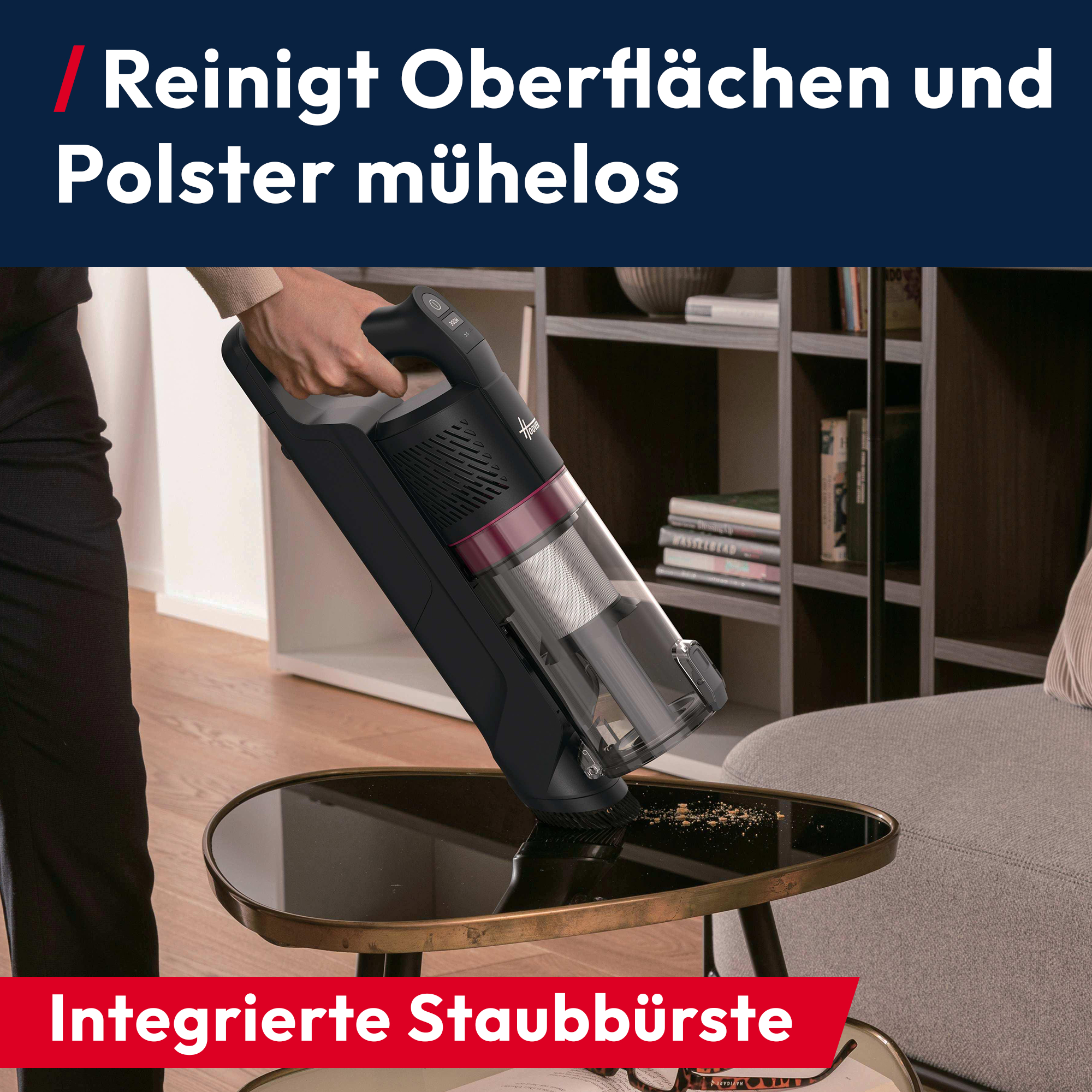 Hand hält Staubsauger, der Krümel von einem Tisch saugt.