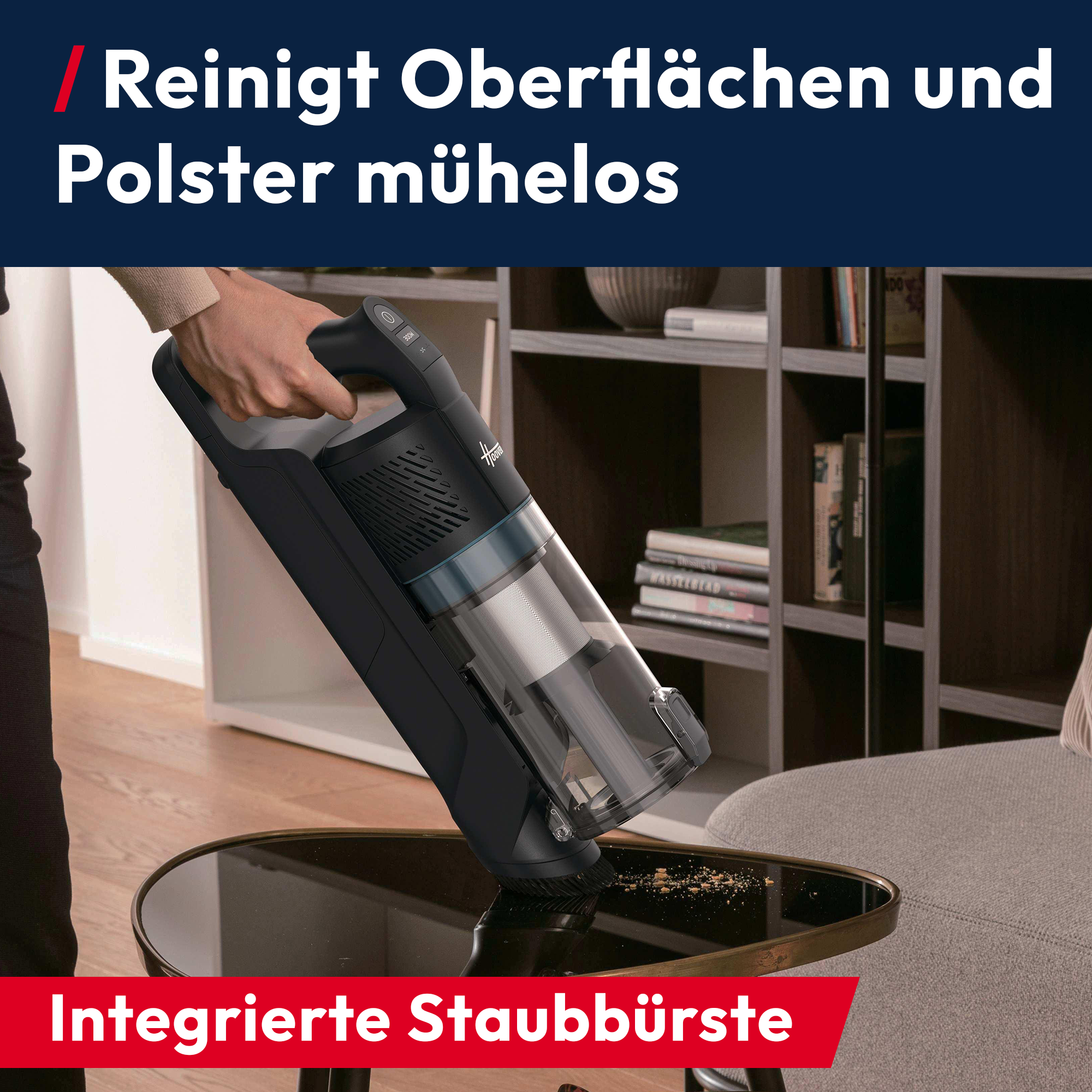 Eine Hand hält einen schwarzen Staubsauger über einem Tisch mit Krümeln.