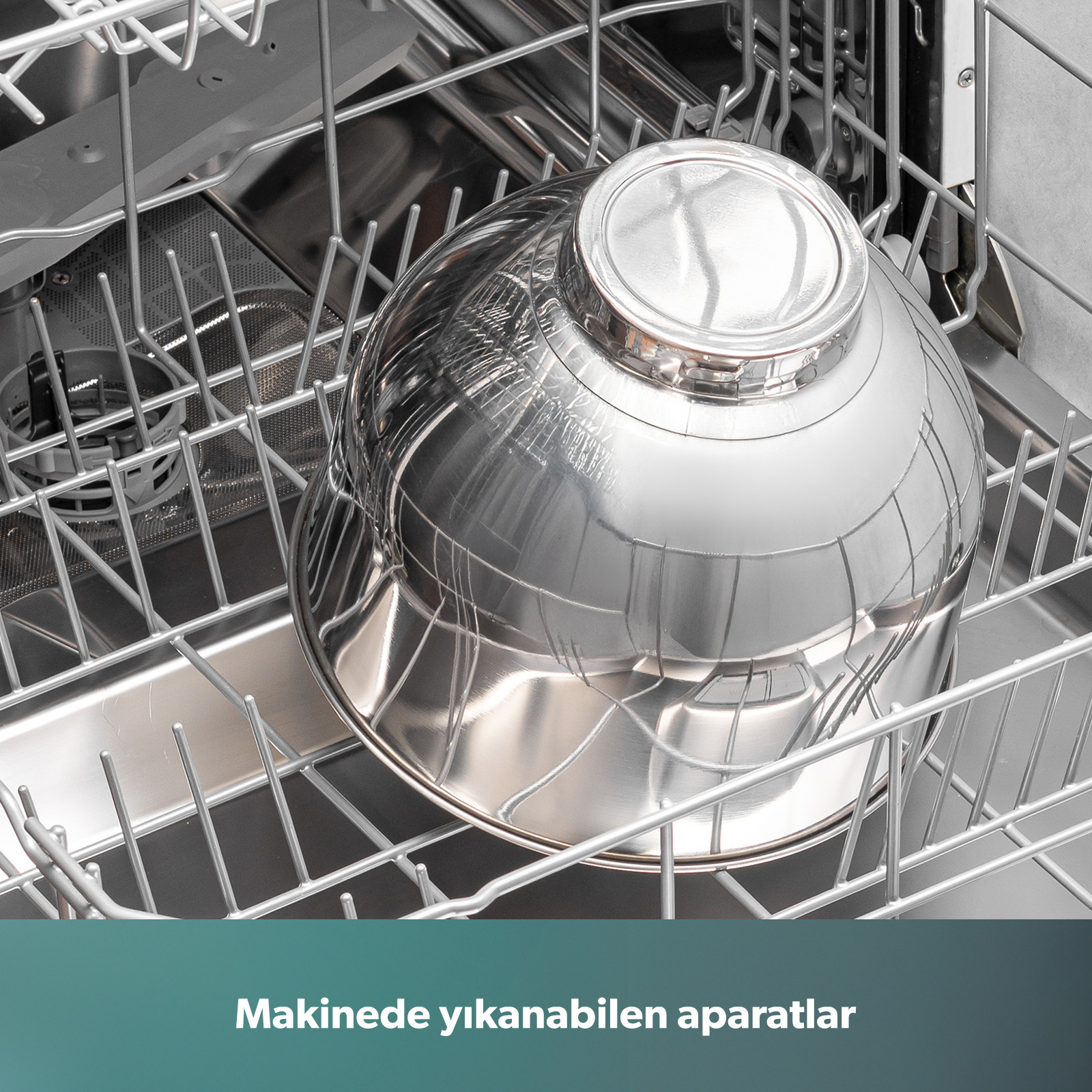 Gümüş rengi bir tencere, açık bulaşık makinesinin üst rafına yerleştirilmiş.