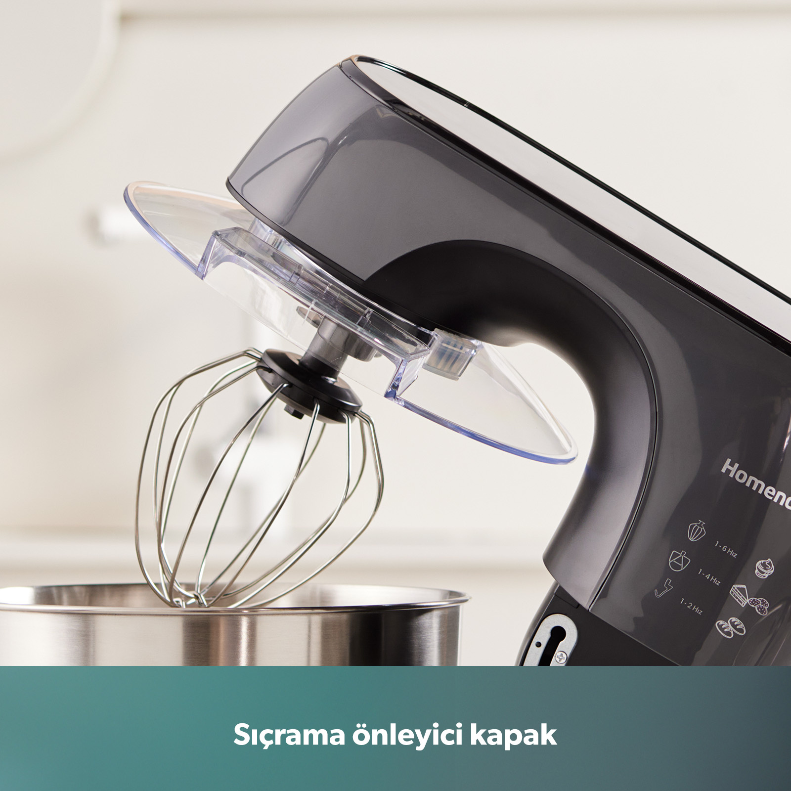 Şeffaf sıçrama önleyici kapaklı ve çırpıcılı koyu renkli mutfak mikseri.