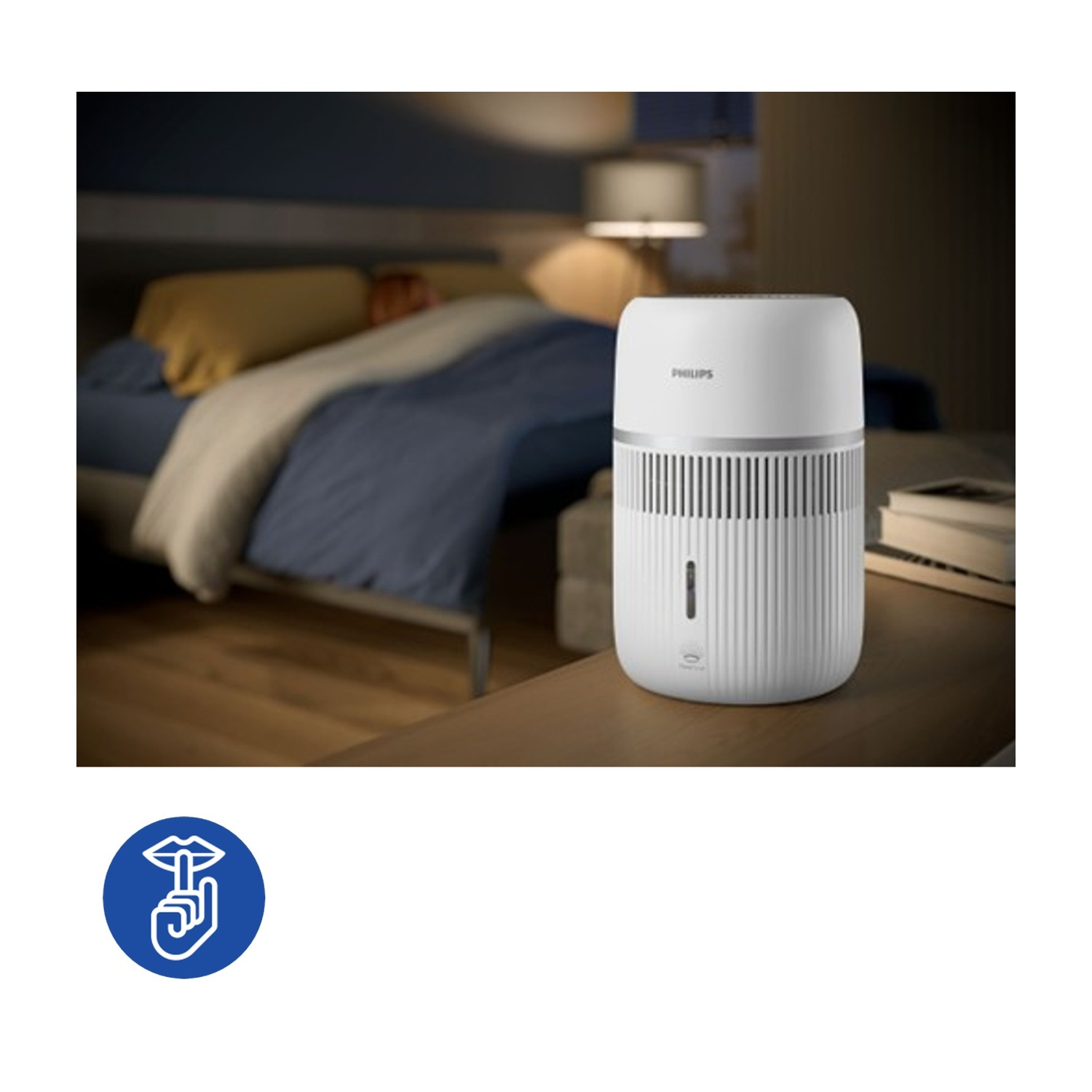 Un purificatore d'aria Philips bianco è su un comodino accanto a un letto.