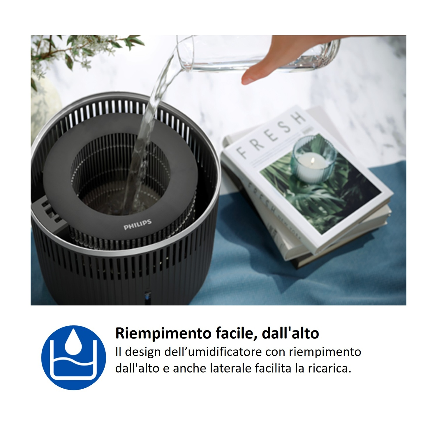 Si versa acqua in un umidificatore Philips; ci sono libri nelle vicinanze.