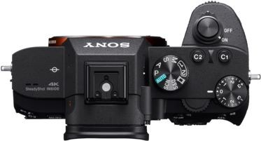 Widok z góry czarnego aparatu Sony z pokrętłami, przyciskami i logo Sony.