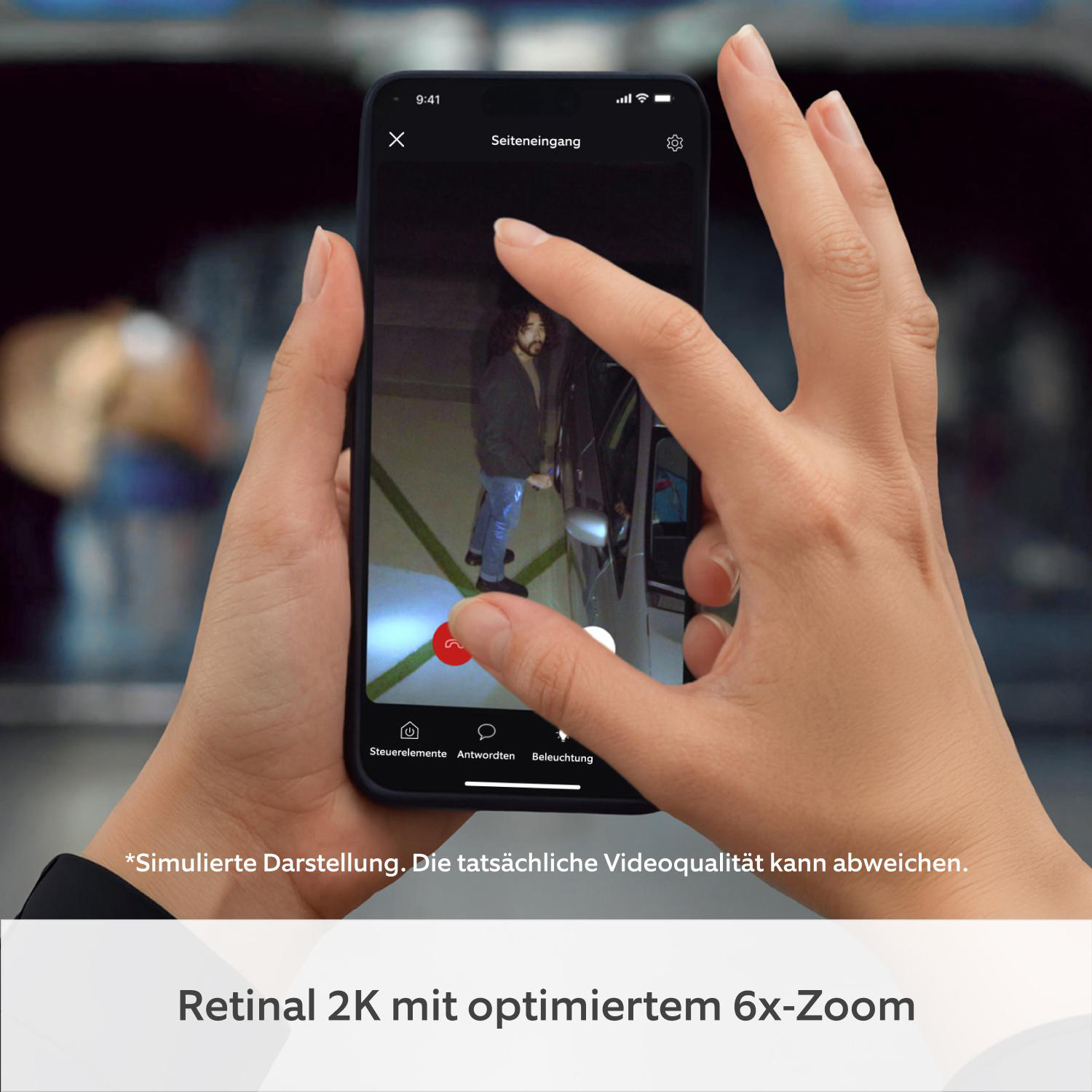 Eine Person hält ein Smartphone, das eine Videoaufnahme einer Person in einem Parkhaus zeigt.